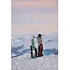 happy young snowboarder couple relax at top of mountain at beautiful sunny winter day