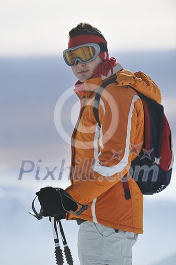 young skier relaxing in snow and looking mountain range at beautiful sunny winter day young skier relaxing in snow and looking mountain range at beautiful sunny winter day