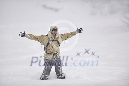 snowboarder relaxing and posing at sunny day on winter season with blue sky in background snowboarder relaxing and posing at sunny day on winter season with blue sky in background