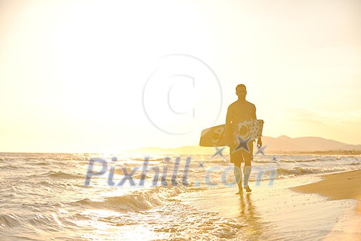 Portrait of a strong young surf man at beach on sunset in a contemplative mood with a surfboard Portrait of a strong young surf man at beach on sunset in a contemplative mood with a surfboard