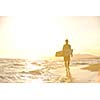 Portrait of a strong young  surf  man at beach on sunset in a contemplative mood with a surfboard