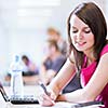 in the library - pretty female student with laptop and books working in a high school library  (color toned image)