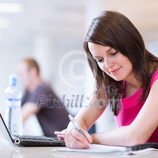 in the library - pretty female student with laptop and books working in a high school library (color toned image) in the library - pretty female student with laptop and books working in a high school library (color toned image)