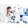 senior male researcher carrying out scientific research in a lab using a microscope (shallow DOF; color toned image)