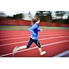 Young woman running at a track and field stadium