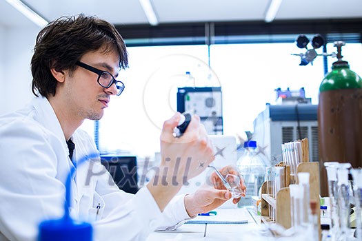 Young male researcher carrying out scientific research in a lab (shallow DOF; color toned image) Young male researcher carrying out scientific research in a lab (shallow DOF; color toned image)