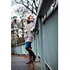 Autumn/winter portrait: young woman dressed in a warm woolen cardigan posing outside in a city park