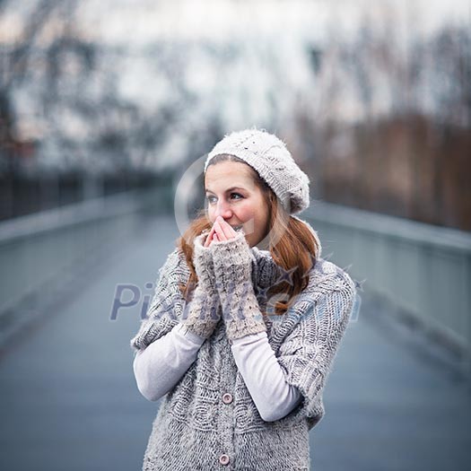 Autumn/winter portrait: young woman dressed in a warm woolen cardigan posing outside in a city park Autumn/winter portrait: young woman dressed in a warm woolen cardigan posing outside in a city park