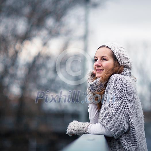 Autumn/winter portrait: young woman dressed in a warm woolen cardigan posing outside in a city park Autumn/winter portrait: young woman dressed in a warm woolen cardigan posing outside in a city park
