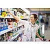 Beautiful young woman shopping for diary products at a grocery store/supermarket (color toned image)