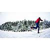 young man cross-country skiing on a snowy forest trail (motion blurred & color toned image)