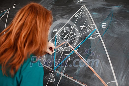 pretty young college student writing on the chalkboard/blackboard during a math class (color toned image; shallow DOF) pretty young college student writing on the chalkboard/blackboard during a math class (color toned image; shallow DOF)