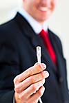 Young businessman holding an ethernet cable - stressing the importance of fast and reliable internet connection for a business (color toned image; shallow DOF)