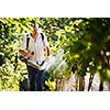 Vintner walking in his vineyard spraying chemicals on his vines