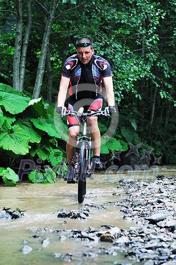 young man drive mountain bike over water river young man drive mountain bike over water river
