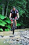 young man drive mountain bike over water river