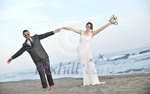 happy just married young couple celebrating and have fun at beautiful beach sunset happy just married young couple celebrating and have fun at beautiful beach sunset