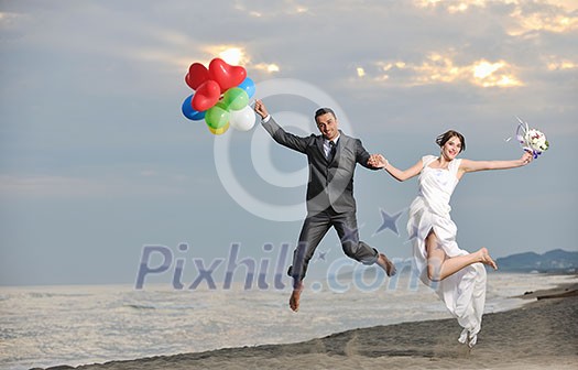 happy just married young couple celebrating and have fun at beautiful beach sunset happy just married young couple celebrating and have fun at beautiful beach sunset