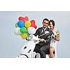 wedding sce of bride and groom just married couple on the beach ride white scooter and have fun
