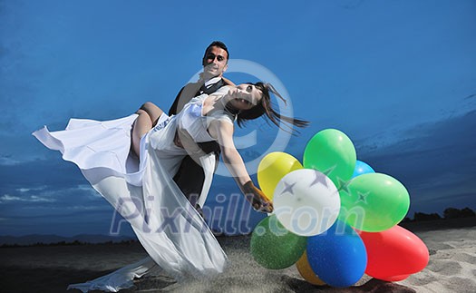 happy just married young couple celebrating and have fun at beautiful beach sunset happy just married young couple celebrating and have fun at beautiful beach sunset