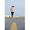 Running in city park. Woman runner outside jogging at morning with Dubai urban scene in background