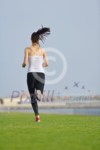 Running in city park. Woman runner outside jogging at morning with Dubai urban scene in background Running in city park. Woman runner outside jogging at morning with Dubai urban scene in background