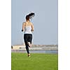 Running in city park. Woman runner outside jogging at morning with Dubai urban scene in background