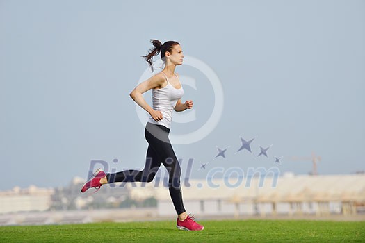 Running in city park. Woman runner outside jogging at morning with Dubai urban scene in background Running in city park. Woman runner outside jogging at morning with Dubai urban scene in background