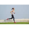 Running in city park. Woman runner outside jogging at morning with Dubai urban scene in background