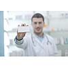portrait of handsome young  pharmacist chemist man standing in pharmacy drugstore