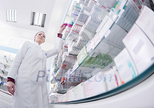Happy cheerful pharmacist chemist woman standing in pharmacy drugstore Happy cheerful pharmacist chemist woman standing in pharmacy drugstore