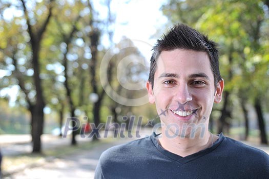 Handsome young man smiling outdoors in nature Handsome young man smiling outdoors in nature