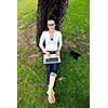 happy young student woman with laptop in city park study