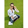 happy young student woman with laptop in city park study