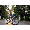 Fit happy young man smiling on mountain bike in park