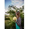 Young woman picking elderflower to make an infusion at home