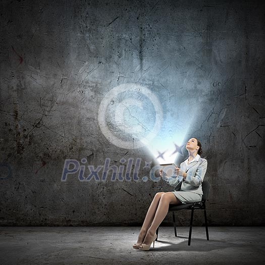 Image of businesswoman sitting on chair with tablet pc in hands Image of businesswoman sitting on chair with tablet pc in hands