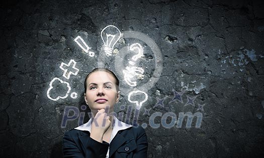 Image of thoughtful businesswoman looking at light bulb Image of thoughtful businesswoman looking at light bulb