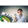 Cute school boy examining objects with magnifying glass. Elements of this image are furnished by NASA