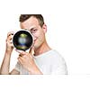 Young pro photographer with digital camera - DSLR and a huge telephoto lens in his well equiped studio, taking photos (color toned image; shallow DOF)
