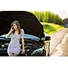 Pretty, young woman calling the roadside service/assistance after her car has broken down