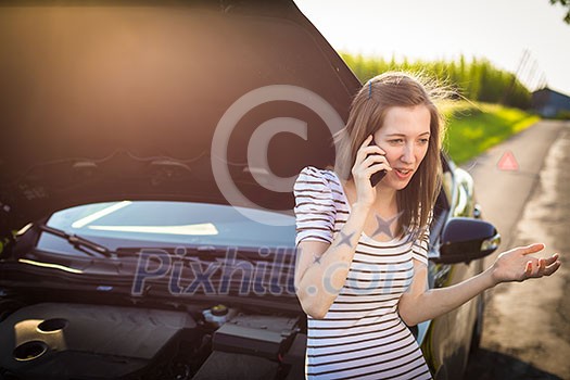 Pretty, young woman calling the roadside service/assistance after her car has broken down Pretty, young woman calling the roadside service/assistance after her car has broken down