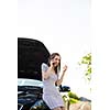 Pretty, young woman calling the roadside service/assistance after her car has broken down