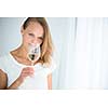 Gorgeous young woman with a glass of wine, smelling the lovely drink, savouring every sip (shallow DOF; color toned image)