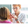 Optometry concept - pretty, young female optometrist examining her patient's eyes, finding the optimal correction to achieve optimal sight