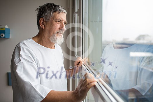 Patient at a hospital, looking from a window in his room, doing much better after the surgery Patient at a hospital, looking from a window in his room, doing much better after the surgery