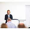 Handsome young man giving a speech at a conference
