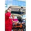 Paramedic taking care of a female patient - calling a hospital