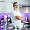 Senior man standing in his renovated, modern kitchen,