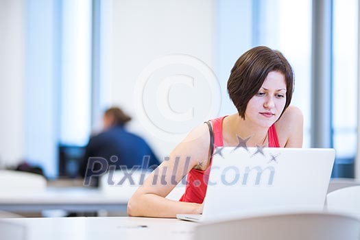 Pretty, young college student studying in the library/a study room at campus , using her modern laptop computer, writing notes, preparing for exams (shallow DOF) Pretty, young college student studying in the library/a study room at campus , using her modern laptop computer, writing notes, preparing for exams (shallow DOF)